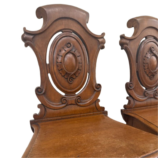 A Pair Of Carved Oak Hall Chairs