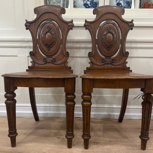 A Pair Of Carved Oak Hall Chairs